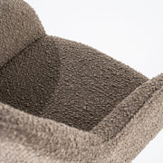 Groene draaistoel in boucléstof met open rug en zwarte trapeziumpoten voor een knusse look aan je eettafel