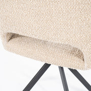 Beige draaistoel met open rug onderaan en zwarte platte stalen poten in een kruisvorm van het merk Eleonora in een knusse teddystof