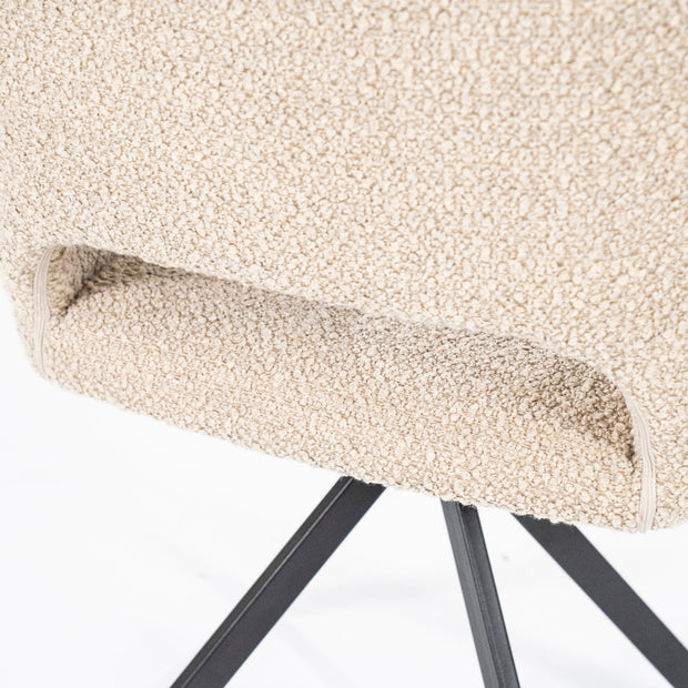Beige draaistoel met open rug onderaan en zwarte platte stalen poten in een kruisvorm van het merk Eleonora in een knusse teddystof